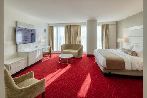 a hotel room with a large bed and a red carpet at Southland Casino Hotel in West Memphis