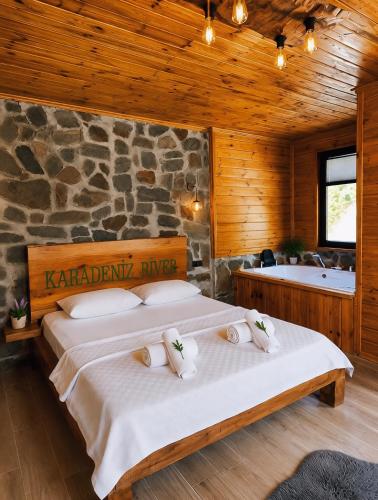 a bedroom with two beds and a stone wall at Ayder River Suite by Karadeniz in Ardeşen