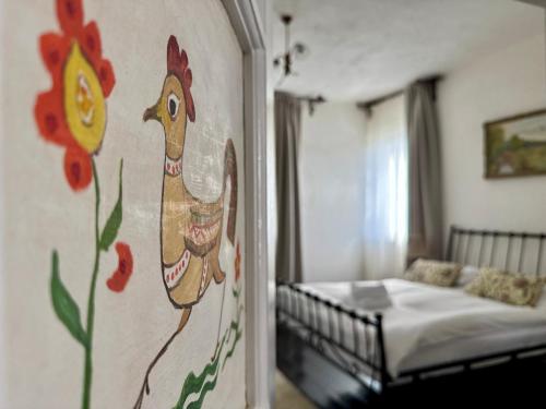 a bedroom with a painting of a chicken on the wall at Casa Alexandra Slătineanu in Bran