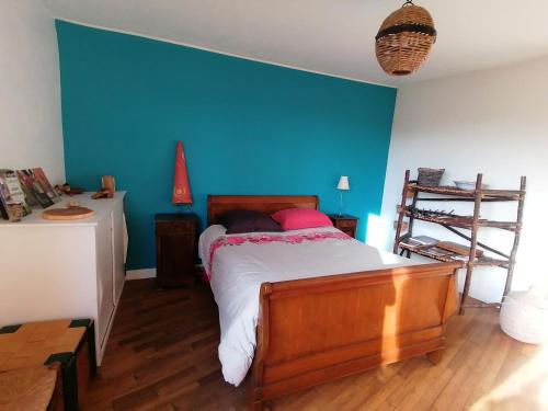 a bedroom with a bed with a blue wall at Douceur des bois du Quercy in Montcuq
