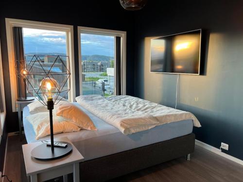 a bedroom with a bed and a large window at Moderne enebolig med gratis parkering in Alta