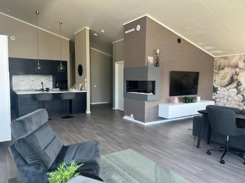 a living room with a couch and chairs and a tv at Moderne enebolig med gratis parkering in Alta