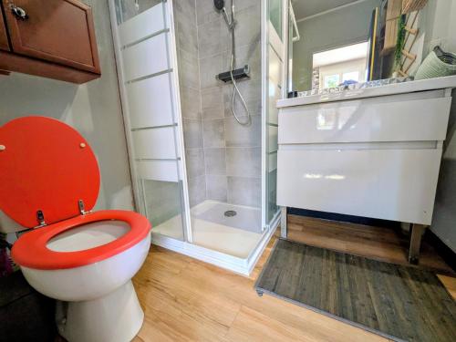 a bathroom with a red toilet and a shower at Le calme de la campagne proximité Center Parcs in Saint-Léger-de-Montbrillais