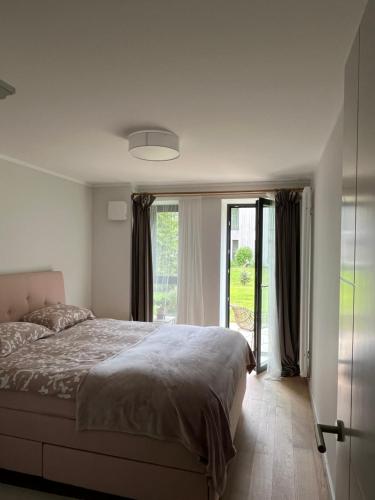 a bedroom with a bed and a large window at Albatross Seaside Escape in Ķesterciems