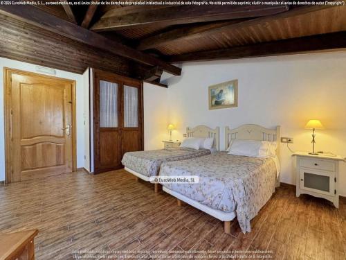 a bedroom with two beds and a wooden floor at Hotel Vitorio in Cudillero