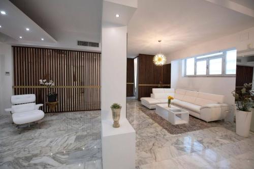 a living room with white furniture and marble floors at La Galleria Milano - 160 sqm Design Apartment, Spa & Parking in Milan