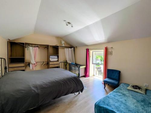 a bedroom with a bed and a chair and a window at Le calme de la campagne proximité Center Parcs in Saint-Léger-de-Montbrillais
