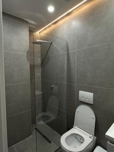 a bathroom with a toilet and a glass shower at Lùmar Hotel in Vlorë