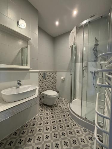 a bathroom with a sink and a toilet and a shower at Szafirowy Dwór Hotel & Restauracja in Gliwice