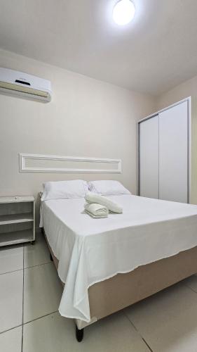 a white bedroom with a large bed with white sheets at Green Paradise Canoa Quebrada in Canoa Quebrada