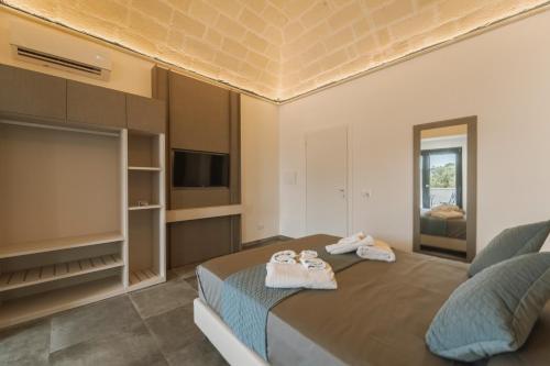 a bedroom with a bed and a flat screen tv at La dimora del cavatore in Favignana