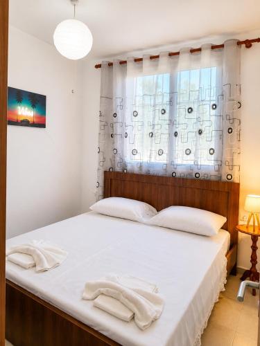 a bedroom with a bed with two towels on it at The Pine House in Fier