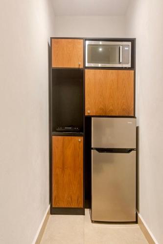 a kitchen with a stainless steel refrigerator and a microwave at Akbal Cancun in Cancún