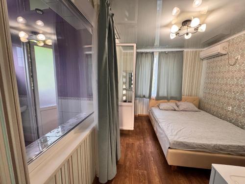 a small bedroom with a bed and a window at Гостевой дом Надежда in Zatoka
