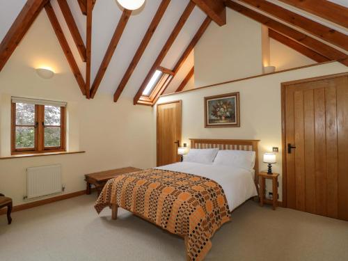 a bedroom with a large bed and a wooden ceiling at Stowey Mead Stables in Bristol