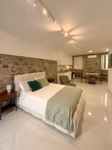 a bedroom with a large bed and a stone wall at Casa Bossa Nova in Fundão