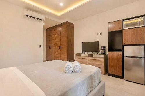 a bedroom with a bed with two white shoes on it at Akbal Cancun in Cancún
