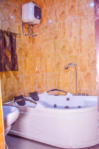 a bathroom with a tub and a sink at 6A Resort LTD in Owerri