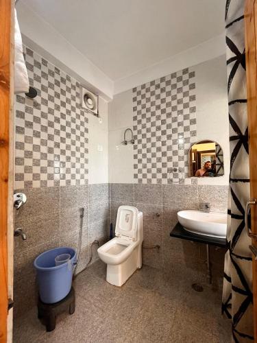 a bathroom with a toilet and a sink at Nomad House in Manāli