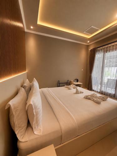 a bedroom with a large bed with white pillows at Qwank Kuta Lombok in Kuta Lombok