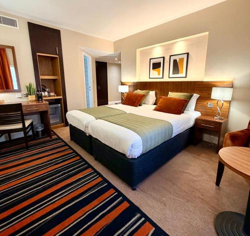 a hotel room with a large bed and a desk at Fenwick Street Hotel by EPIC, Central Rooms Near Waterfront & Liverpool ONE in Liverpool