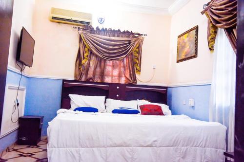 a bedroom with a large white bed with a curtain at 6A Resort LTD in Owerri