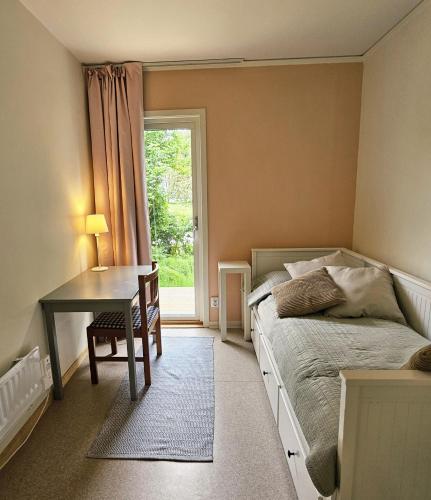 a bedroom with a bed and a desk and a window at Brukshotellet Öland - Vandrarhem in Degerhamn