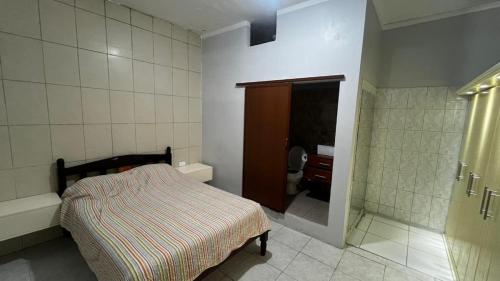 a small bedroom with a bed and a bathroom at ACOGEDOR DEPa CON GARAGE PRIVADO in Nueva Loja