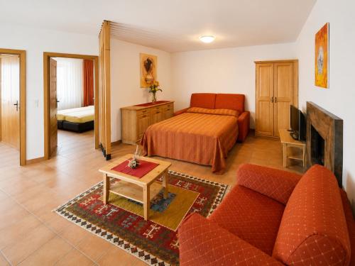 a living room with a bed and a couch at Hotel-Aparthotel San Bernardino in San Bernardino