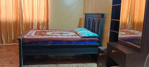 a small bedroom with a bed and a dresser at Michenzani rooms apartment in Ngambo