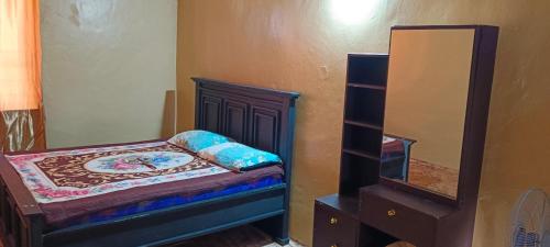 a small bedroom with a bed and a mirror at Michenzani rooms apartment in Ngambo