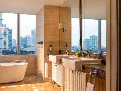 a bathroom with two sinks and a bath tub at Fairmont Makati in Manila
