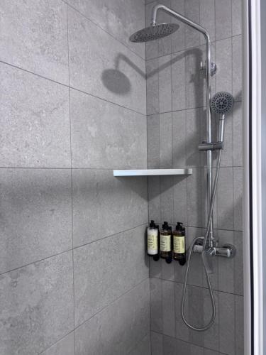 a shower with three bottles of soap sitting on a shelf at La LLar in Carboneras