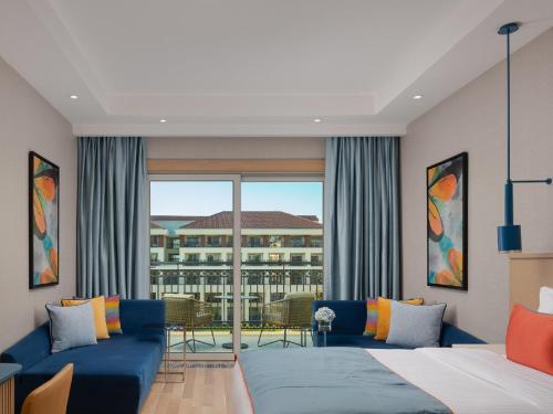 a living room with two beds and a large window at Rixos Water World Aktau - Theme Park Free Access in Aktau
