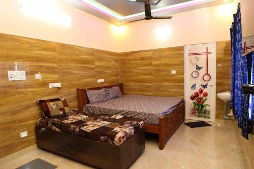 a bedroom with a bed in a room with wooden walls at Malar Resort in Wodapatti