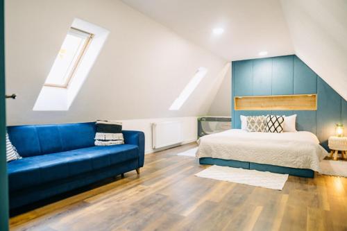a bedroom with a bed and a blue couch at Demeter Guesthouse WOLF Siklod in Şiclod