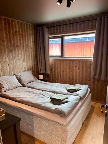a large bed in a room with a window at New! Mountain apartment close to Hardangervidda in Eidfjord