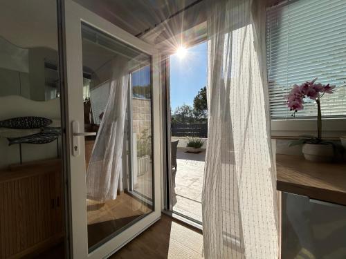 a room with a sliding glass door with a window at Beachfront house Miamore - 10 m from the sea in Pašman