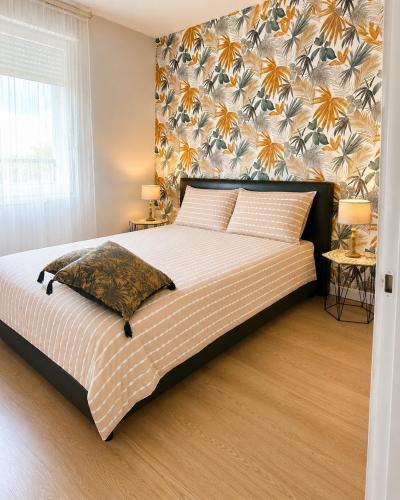 a bedroom with a large bed with a floral wall at Apprt la teste de buch in La Teste-de-Buch