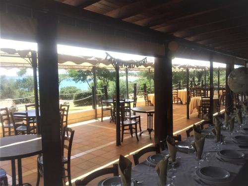 un restaurant avec des tables et des chaises sur une terrasse dans l'établissement Villetta Indipendente Sardegna, à Villaputzu