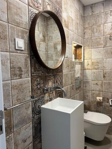 a bathroom with a sink and a mirror and a toilet at Tavira Central Harmony in Tavira