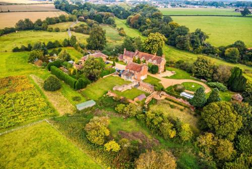 an aerial view of a house on a green field at Historic 6-Bed Manor near Shifnal, Parking in Shifnal