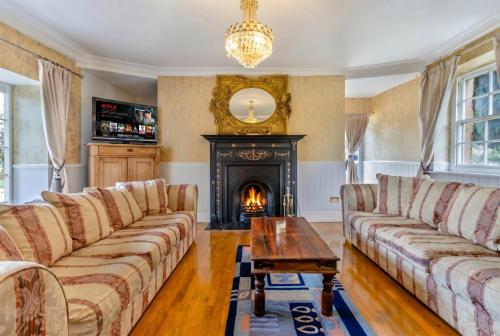 a living room with a couch and a fireplace at Historic 6-Bed Manor near Shifnal, Parking in Shifnal