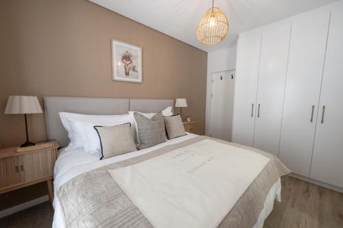 a bedroom with a large white bed with pillows at Sout Huijs Langebaan with hot tub in Langebaan