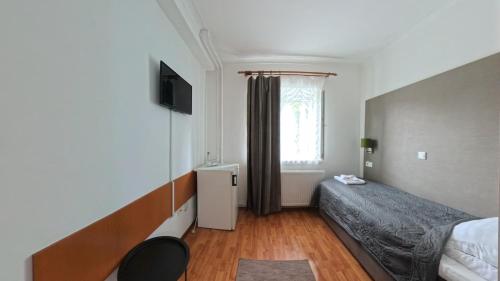a small bedroom with a bed and a window at Pensiunea Diskret in Sovata