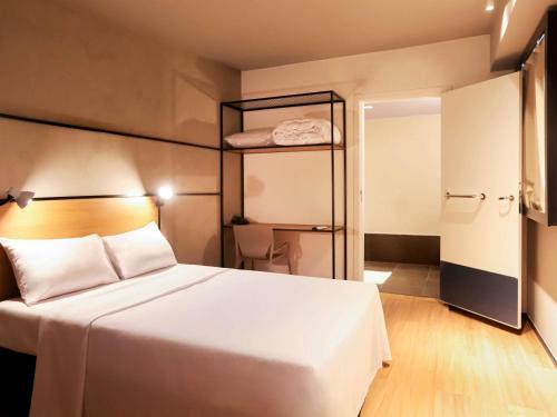 ein Schlafzimmer mit einem großen weißen Bett und einem Kleiderschrank in der Unterkunft ibis Cuiaba Shopping in Cuiabá