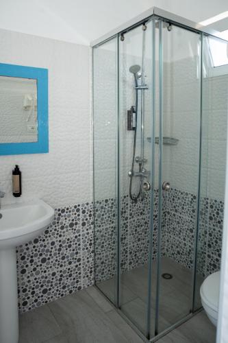 a bathroom with a shower with a sink and a toilet at Hotel Riviera Dhermi in Dhërmi