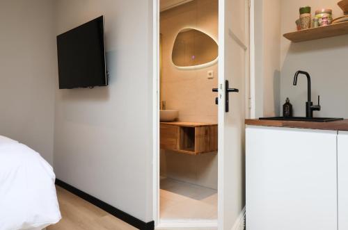 a bedroom with a door open to a bathroom with a sink at City Suite Sneek in Sneek