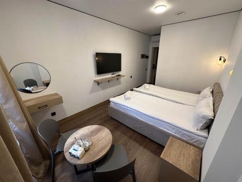 a small hotel room with a bed and a table at Тихий Замок Джал in Bishkek