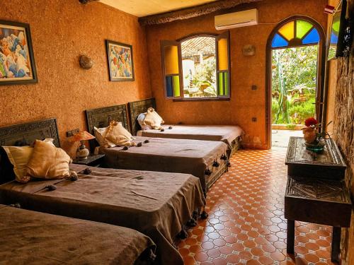 a room with three beds in a room at Auberge le Refuge in Agadir